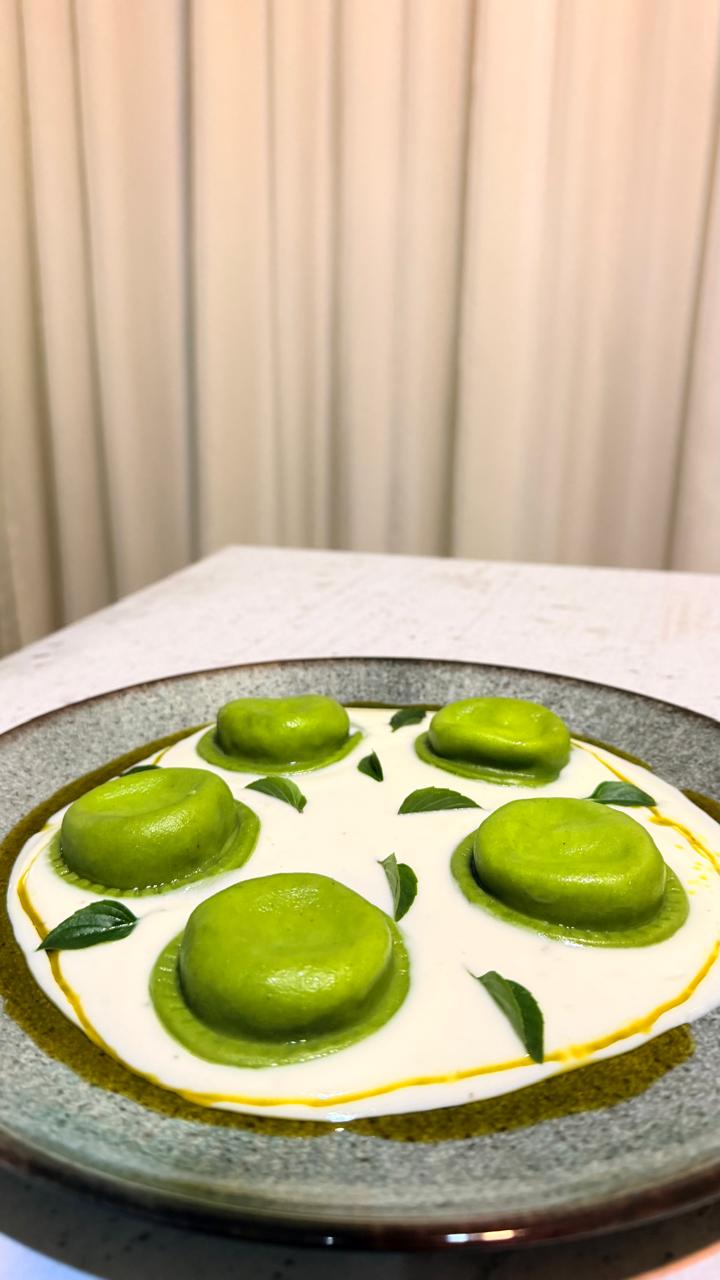 Sorrentino artesanal verde servido com molho cremoso